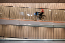 910544 Afbeelding van een fietser in de pas geopende fietsenstalling onder het Stationsplein te Utrecht.